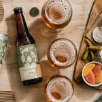 Bière ipa viriat fraîcheur : canette et verres sur table bois, fromages et crackers